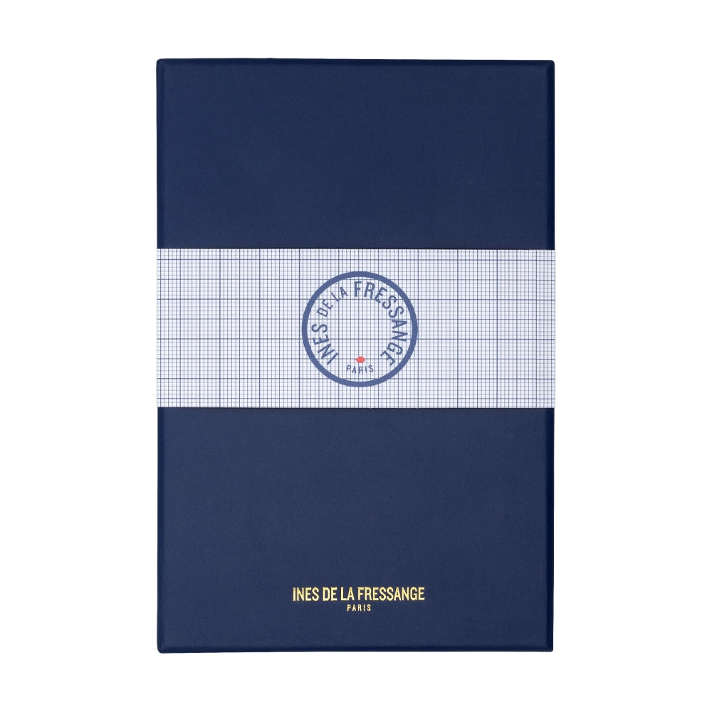 Un écrin fermé du stylo plume bleu sarcelle et fuchsia de la marque Inès de la Fressange est posé sur un fond blanc. L'écrin est visible dans son intégralité, mettant en avant son design et son logo.