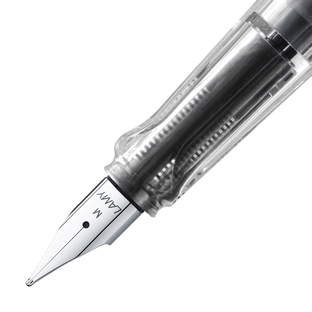 Gros plan sur la plume du stylo plume Lamy Vista Transparent, taille M. La plume en acier inoxydable est clairement visible à travers le corps transparent du stylo, mettant en avant sa finition soignée et sa fonctionnalité pour une écriture fluide.