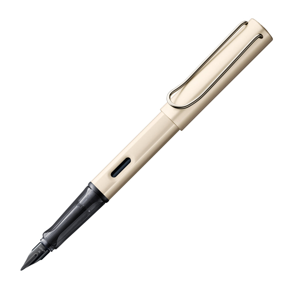 Un stylo plume Lamy Crème LX en finition palladium, incliné à 45 degrés avec le bouchon retiré, est présenté sur un fond blanc. Le stylo plume se distingue par sa finition palladium élégante et son design crème moderne, offrant une expérience d'écriture raffinée et stylée.