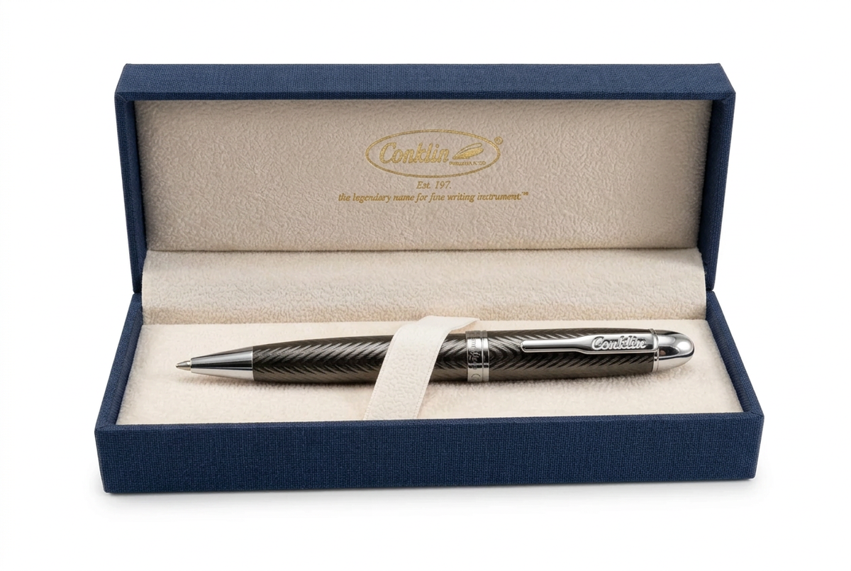 Stylo bille Conklin Herringbone Gun Metal dans un écrin Conklin ouvert sur fond blanc