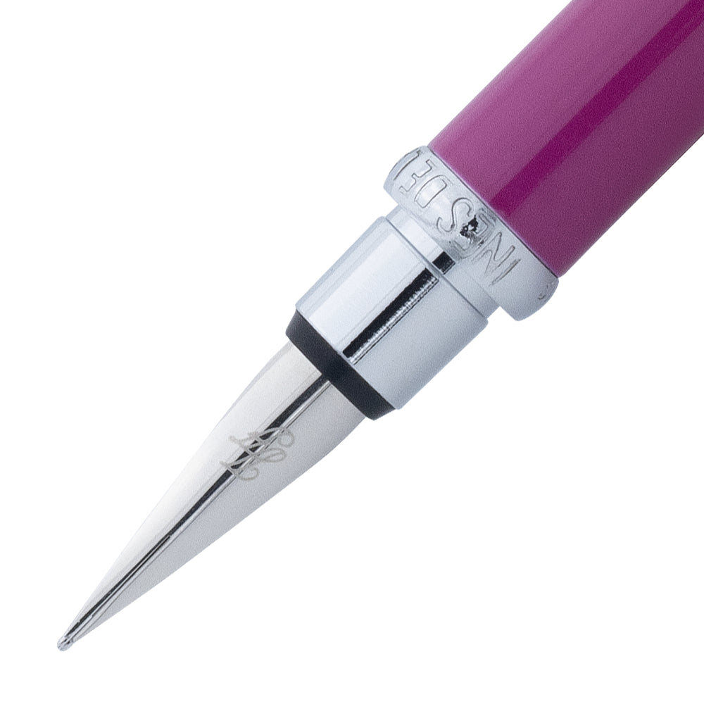 Un gros plan de la plume du stylo plume fuchsia avec attributs chromes de la marque Inès de la Fressange. La plume est visible en détail, avec le stylo incliné à 45 degrés et le bouchon retiré, placé parallèlement au stylo, sur un fond blanc.