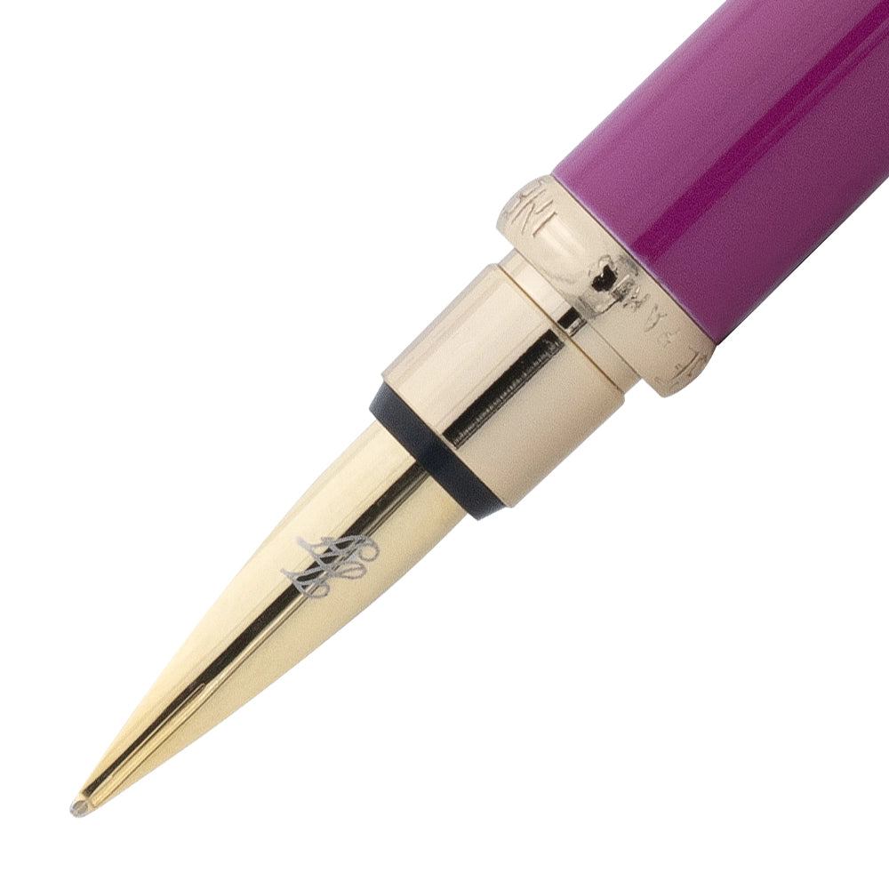 Un gros plan de la plume du stylo plume fuchsia rose avec attributs dorés de la marque Inès de la Fressange. La plume est visible en détail, avec le stylo incliné à 45 degrés et le bouchon retiré, placé parallèlement au stylo, sur un fond blanc.