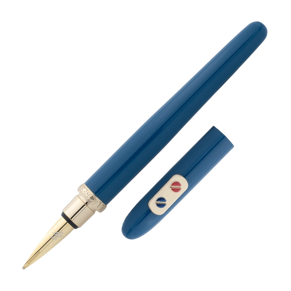 Un stylo plume bleu sarcelle avec attributs dorés de Inès de la Fressange est incliné à 45 degrés, avec le bouchon retiré et placé parallèlement au stylo, sur un fond blanc.