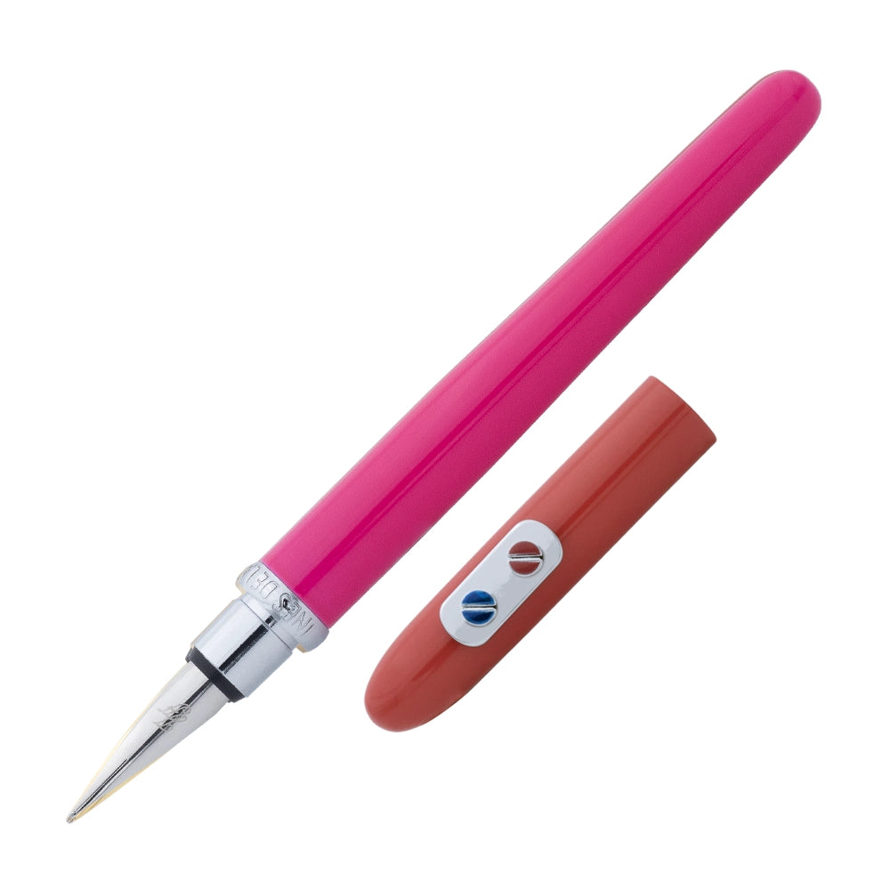 Un stylo plume rose rouge avec attributs chromés de la marque Inès de la Fressange est incliné à 45 degrés, avec le bouchon retiré et placé parallèlement au stylo, sur un fond blanc.